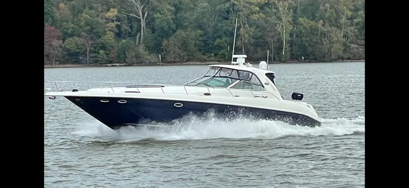 Slide: The Image of 2004 Sea Ray 460 Sundancer cruising on a lake with forested shoreline. - 7