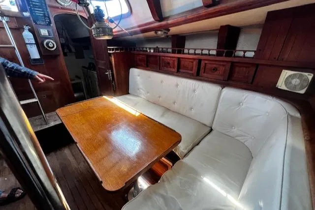 Slide: The Image of Cozy 1978 Custom Fantasia yacht interior with wooden table and white cushioned seating. - 1