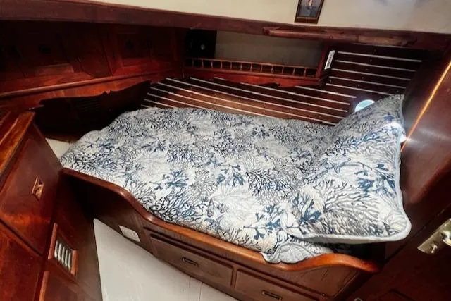 Slide: The Image of Cozy cabin interior of 1978 Custom Fantasia C/C Double Ended Cutter with wooden finish and patterned bedding. - 15