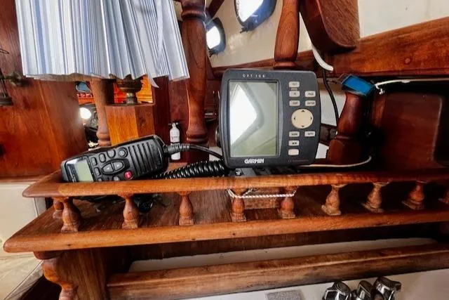 Slide: The Image of Wooden boat interior with navigation equipment, including a Garmin device and radio, on a 1978 Fantasia Cutter. - 9