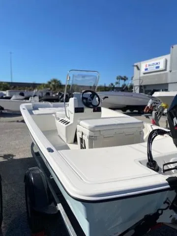 Slide: The Image of 2025 Mako Pro Skiff 15 CC boat with center console and outboard motor, parked outdoors. - 10