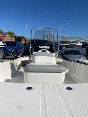 Slide: The Image of 2025 Mako Pro Skiff 15 CC boat, white interior, parked outdoors under clear blue sky. - 4