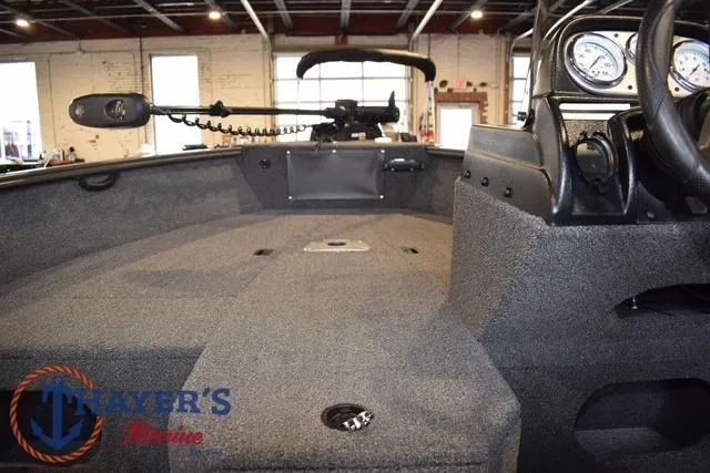 Slide: The Image of 2022 Lund 1675 Adventure Sport boat interior with carpeted deck and steering console. - 14