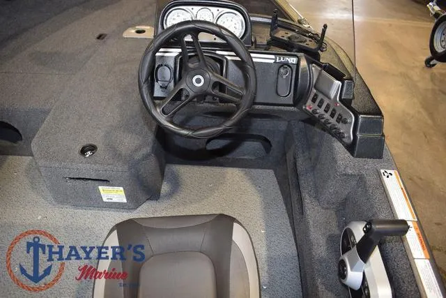 Slide: The Image of 2022 Lund 1675 Adventure Sport boat interior with steering wheel and controls. - 15