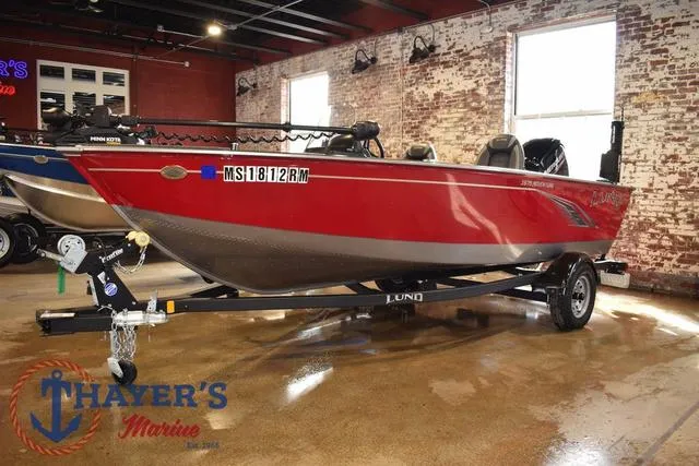 Slide: The Image of 2022 Lund 1675 Adventure Sport boat in showroom, red exterior, displayed at Thayer's Marine. - 2