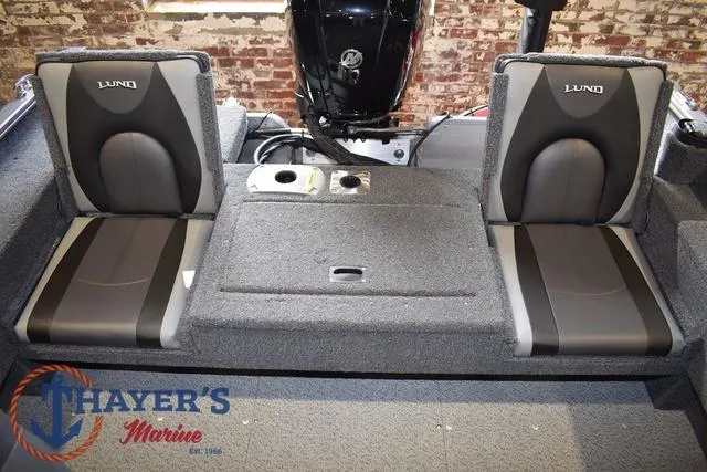 Slide: The Image of 2022 Lund 1675 Adventure Sport boat interior with dual seats and Thayer's Marine logo. - 22