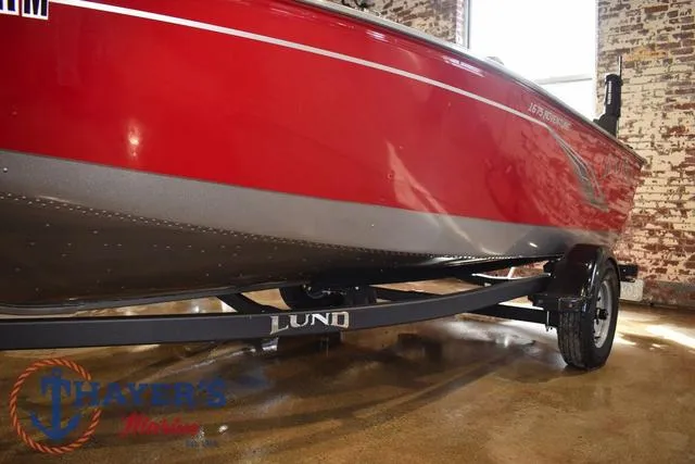 Slide: The Image of 2022 Lund 1675 Adventure Sport boat in red, displayed indoors on a trailer. - 36