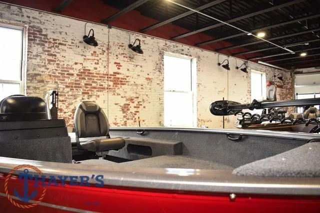 Slide: The Image of 2022 Lund 1675 Adventure Sport boat in showroom with brick walls and industrial lighting. - 7
