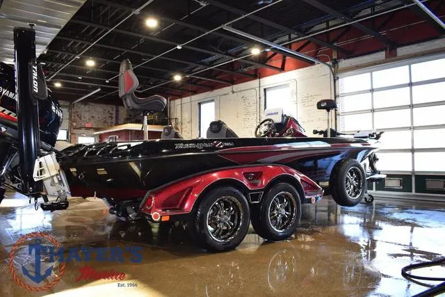Slide: The Image of 2017 Ranger Z521C boat in showroom, black and red design, dual axle trailer. - 2