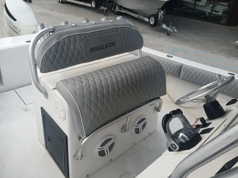 Slide: The Image of 2001 Regulator 32 boat interior with gray quilted seating and steering console. - 11