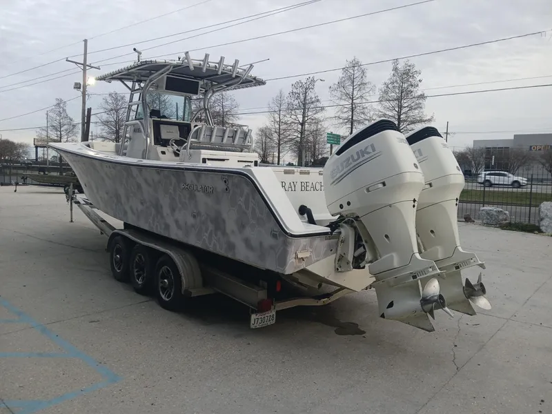 Slide: The Image of 2001 Regulator 32 boat on trailer with dual Suzuki outboard engines, parked outdoors. - 16