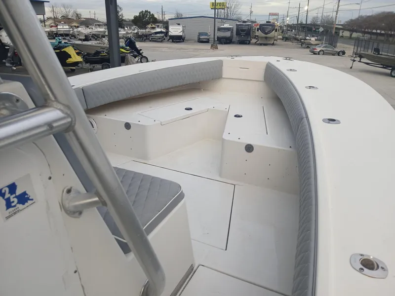 Slide: The Image of 2001 Regulator 32 boat interior with seating and storage, displayed outdoors. - 6
