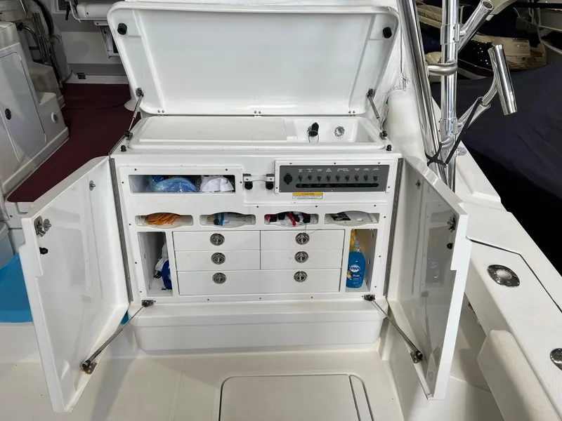 Slide: The Image of Open storage compartment on 2011 Rampage 41 Express boat with organized shelves and drawers. - 9