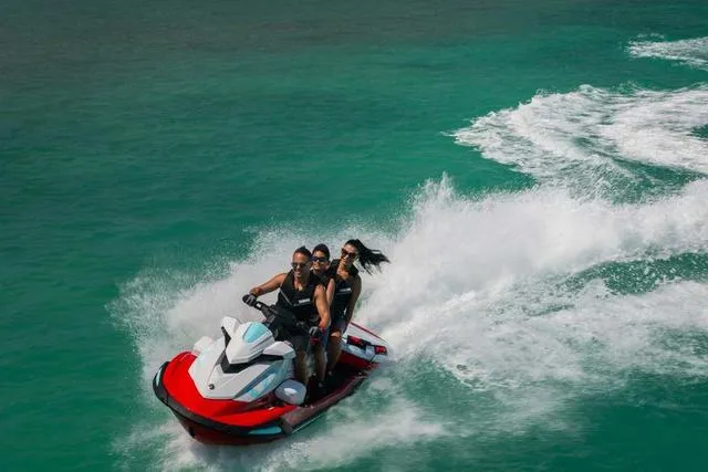 Slide: The Image of 2025 Yamaha Waverunners VX Limited jet ski on turquoise water, three riders enjoying a thrilling ride. - 17