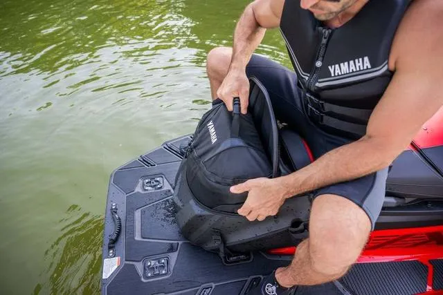 Slide: The Image of Man on 2025 Yamaha Waverunner VX, handling storage bag on water. - 17