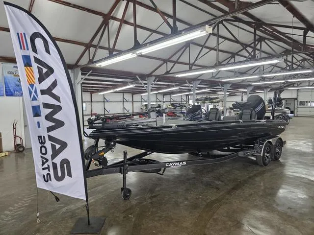 Slide: The Image of 2025 Caymas CX21 Pro boat displayed indoors with Caymas Boats banner. - 2