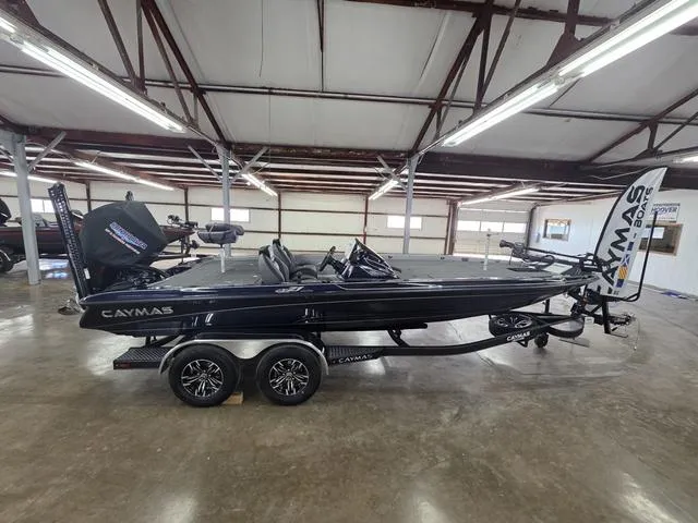 Slide: The Image of 2025 Caymas CX21 Pro boat in showroom, sleek black design, dual axle trailer. - 6