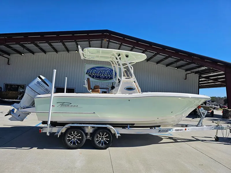 The Image of 2025 Pioneer 222 Sportfish boat on trailer, parked outside a warehouse. - 1