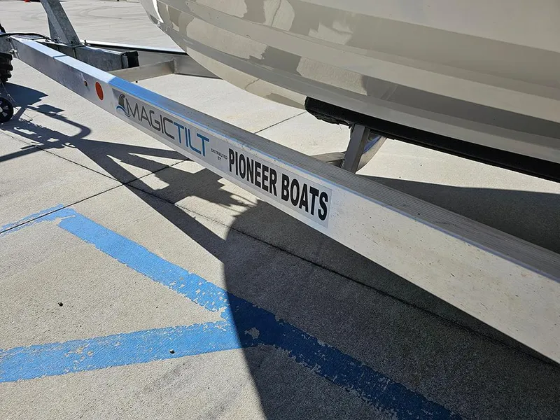 Slide: The Image of Trailer for 2025 Pioneer 222 Sportfish boat by Magic Tilt, parked on concrete. - 11