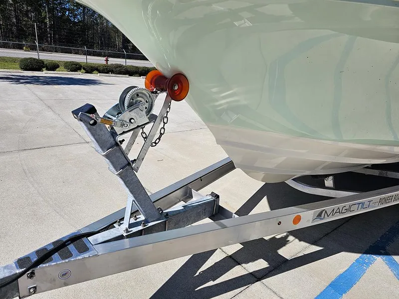 Slide: The Image of 2025 Pioneer 222 Sportfish boat on Magic Tilt trailer in sunny outdoor setting. - 12