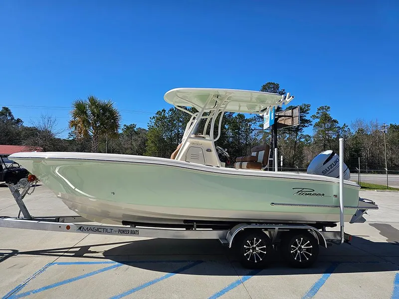 Slide: The Image of 2025 Pioneer 222 Sportfish boat on trailer, parked outdoors under clear blue sky. - 6