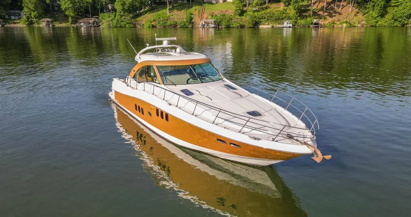 Slide: The Image of 2006 Sea Ray 60 Sundancer yacht on calm water, surrounded by lush greenery. - 5