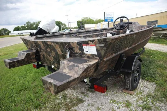 Slide: The Image of 2024 Lowe Roughneck 1660 Add on Console Jet boat, camo design, parked on trailer. - 7
