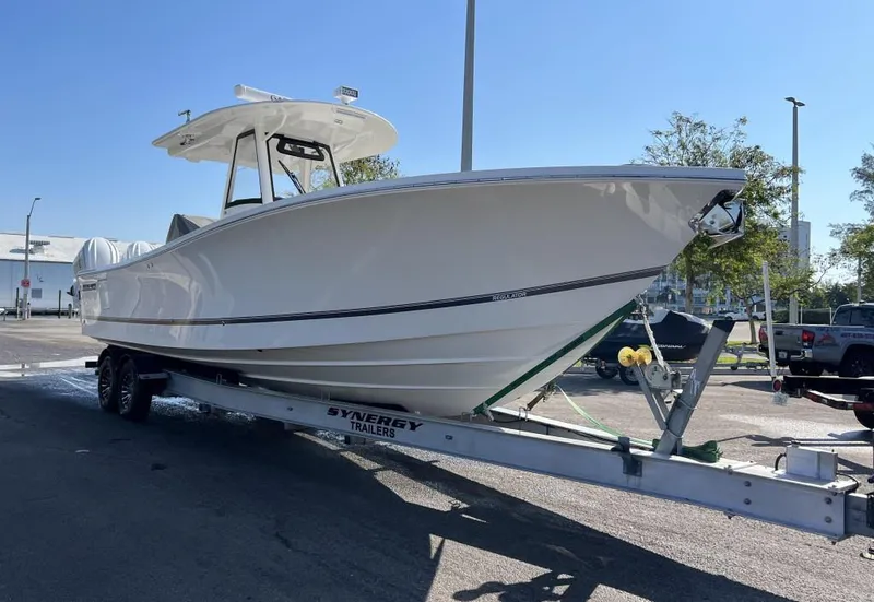 The Image of 2022 Regulator 34 boat on trailer, parked outdoors under clear blue sky. - 0