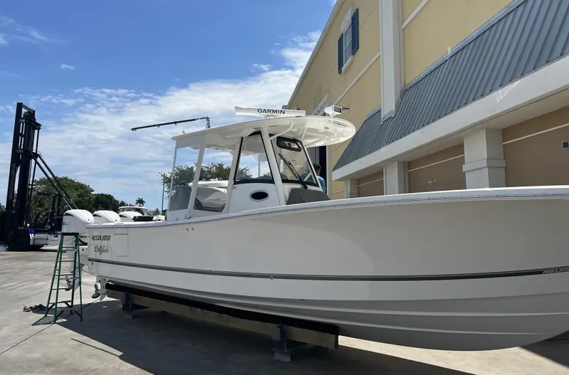 Slide: The Image of 2022 Regulator 34 boat on display outside a building under a clear sky. - 10