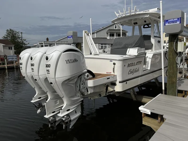 Slide: The Image of 2022 Regulator 34 boat with triple Yamaha 300 engines docked at marina. - 3