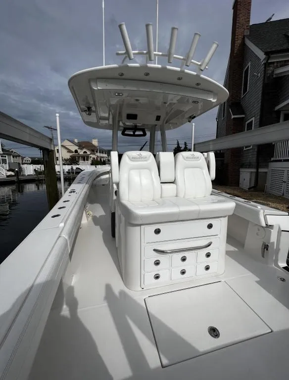 Slide: The Image of 2022 Regulator 34 boat with dual seats and rod holders, docked near waterfront homes. - 6