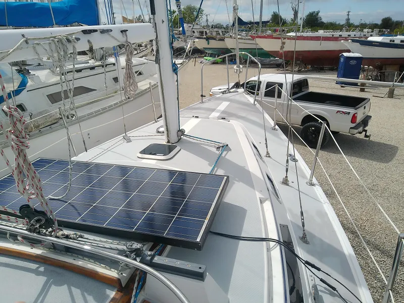 Slide: The Image of Catalina 30 MkII sailboat with solar panel, docked near a white pickup truck. - 12