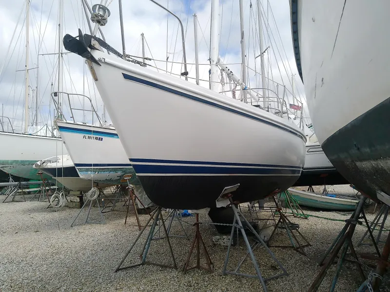 Slide: The Image of 1990 Catalina 30 MkII sailboat on stands in a boatyard, surrounded by other vessels. - 2
