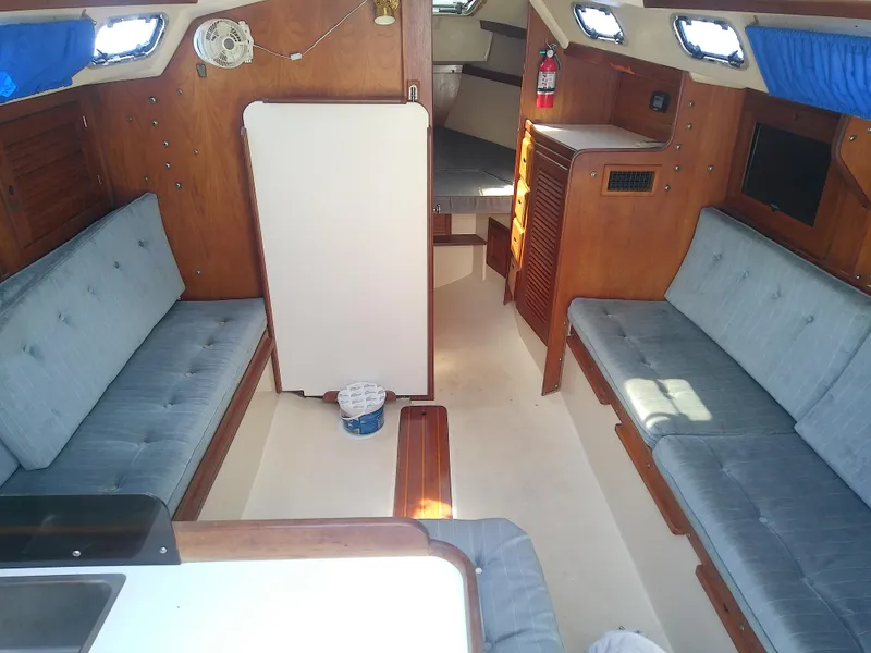 Slide: The Image of Interior of a 1990 Catalina 30 MkII sailboat with blue cushioned seating. - 24