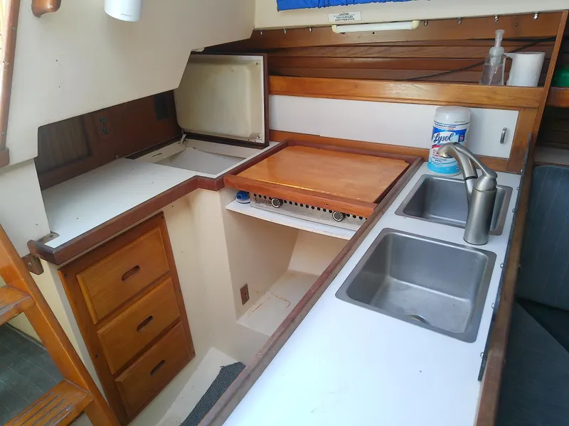 Slide: The Image of Catalina 30 MkII 1990 yacht kitchen with dual sinks and wooden cabinetry. - 26