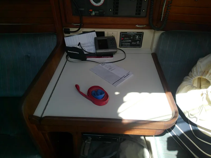 Slide: The Image of Navigation station inside a 1990 Catalina 30 MkII sailboat, featuring equipment and documents. - 31
