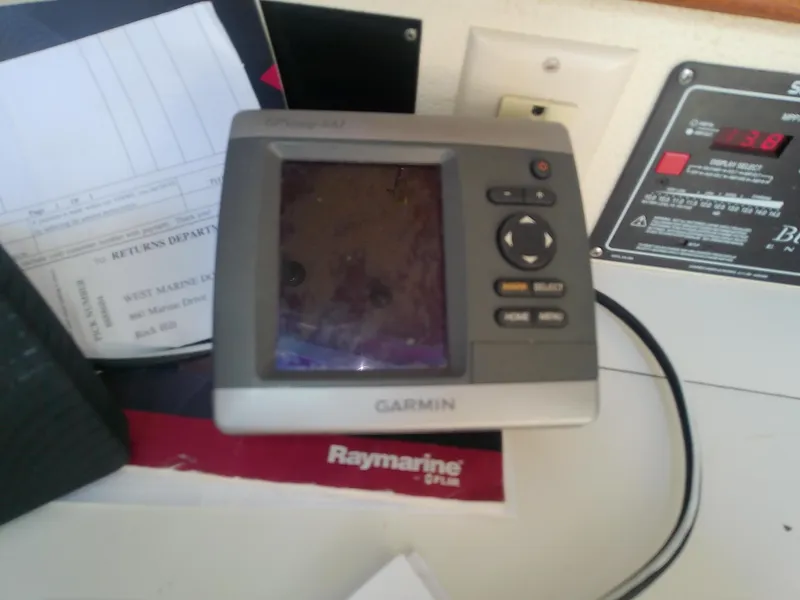 Slide: The Image of Garmin GPS device on a Catalina 30 MkII, 1990 model, with Raymarine manual nearby. - 33
