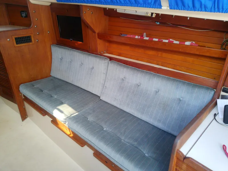 Slide: The Image of Interior of 1990 Catalina 30 MkII sailboat with blue cushioned seating and wooden paneling. - 36