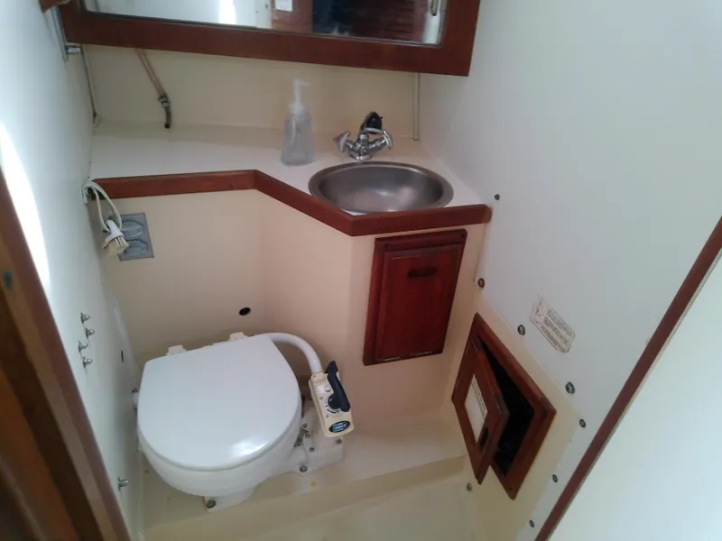 Slide: The Image of 1990 Catalina 30 MkII boat bathroom with sink, toilet, and wooden cabinetry. - 42