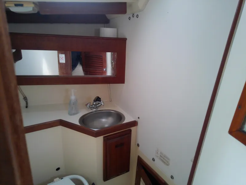 Slide: The Image of 1990 Catalina 30 MkII yacht bathroom with sink, mirror, and wooden cabinetry. - 43