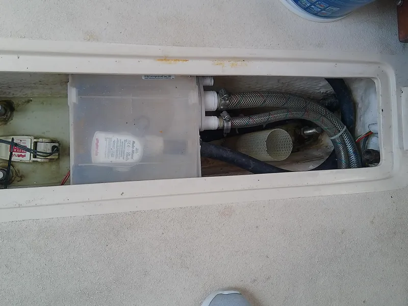 Slide: The Image of 1990 Catalina 30 MkII boat compartment with hoses and a plastic container. - 45