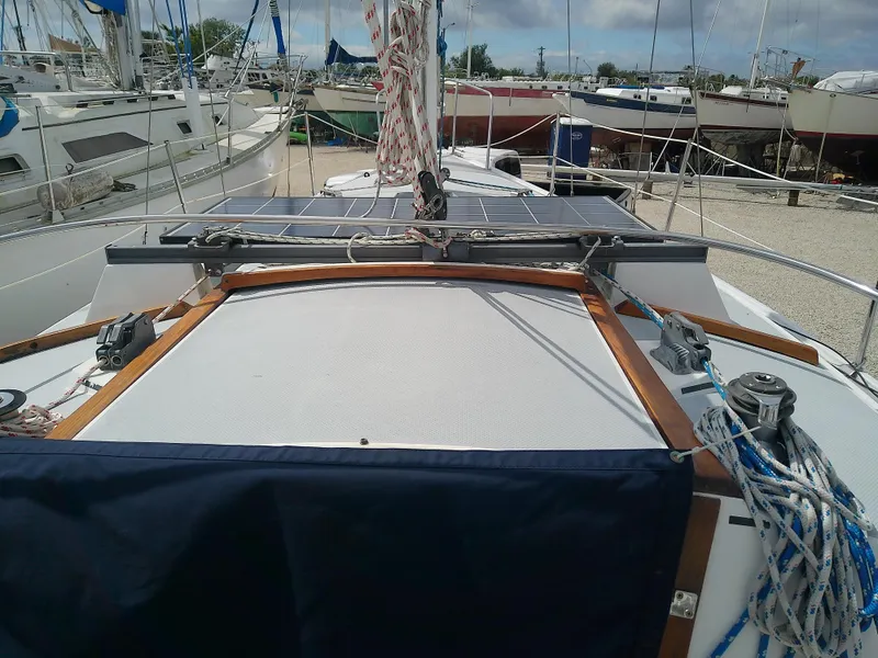 Slide: The Image of 1990 Catalina 30 MkII sailboat deck with solar panels and rigging in a marina. - 7