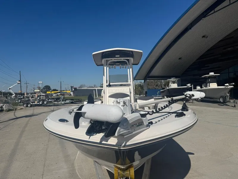 Slide: The Image of 2018 Robalo 246 Cayman boat displayed outdoors near a modern building. - 4