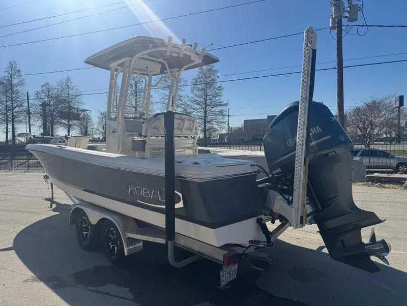 Slide: The Image of 2018 Robalo 246 Cayman boat on trailer with Yamaha outboard motor, parked outdoors. - 8