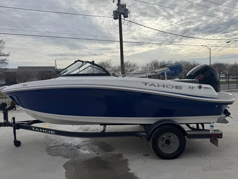 Slide: The Image of 2022 Tahoe 185 S boat on trailer, blue and white design, parked outdoors. - 7