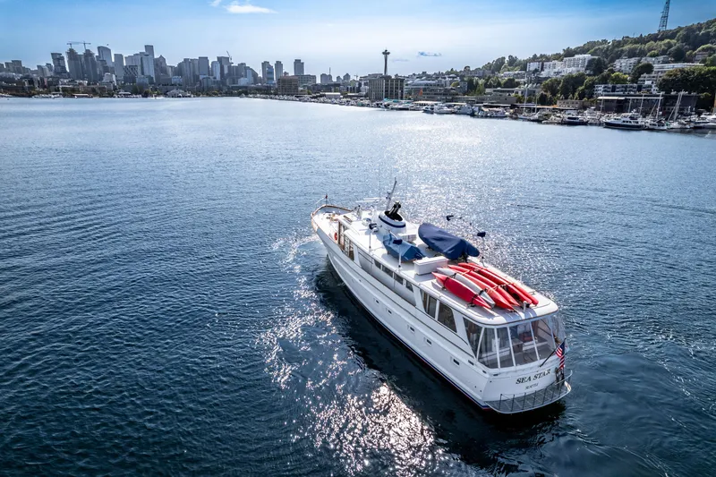 Slide: The Image of 1965 Burger Motoryacht cruising on water with city skyline in the background. - 10