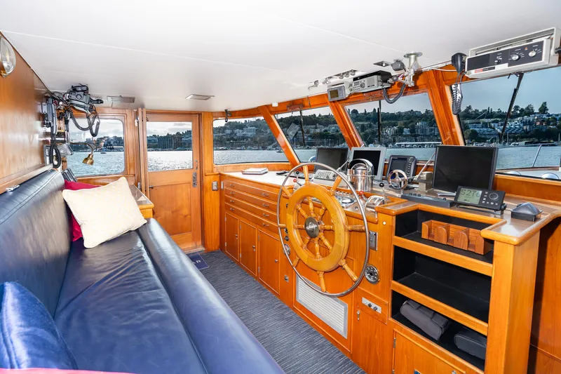 Slide: The Image of Interior of a 1965 Burger Motoryacht with wooden helm and seating area. - 15