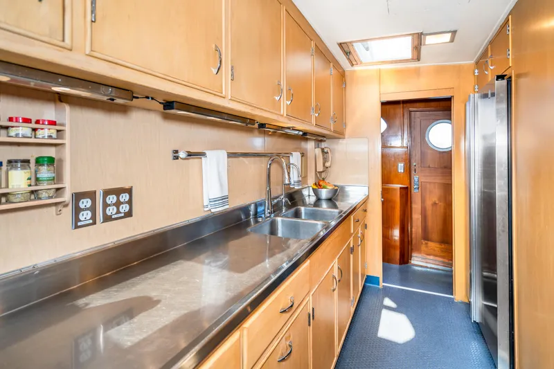 Slide: The Image of Galley kitchen in 1965 Burger Motoryacht with stainless steel countertops and wooden cabinets. - 26