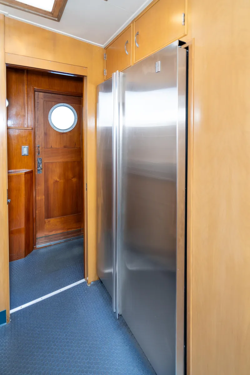 Slide: The Image of Wood-paneled hallway with stainless steel appliances on a 1965 Burger Motoryacht. - 27
