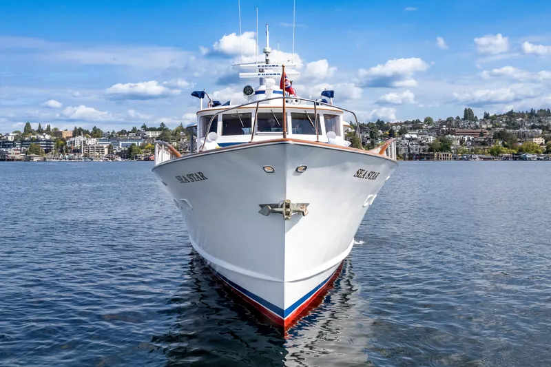 Slide: The Image of Front view of a 1965 Burger Motoryacht on calm water under a blue sky. - 3
